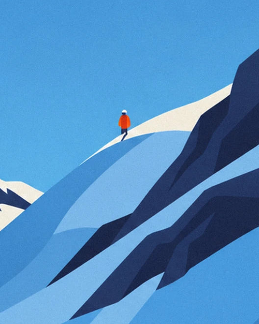 A small figure in an orange jacket walking along the snowy ridge beneath a wide blue sky