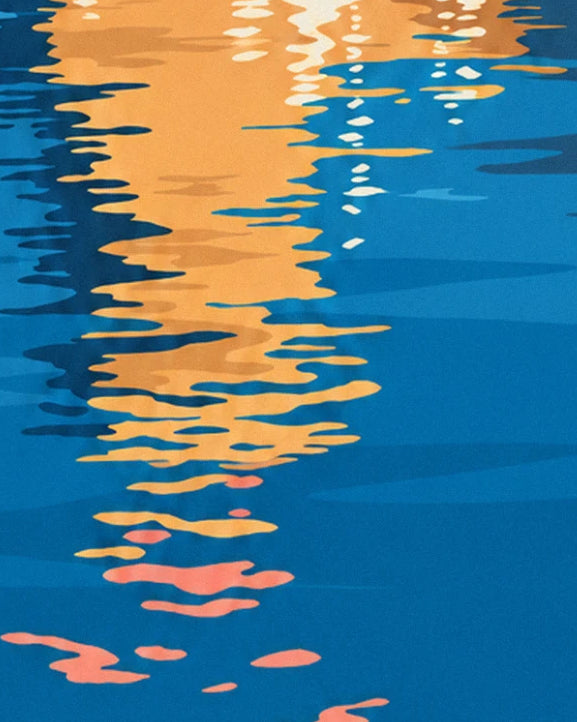 Golden and pink reflections of the bell tower dancing on the deep blue water