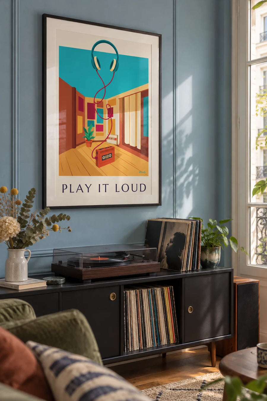 Poster of a cassette player and headphones, “Play It Loud”: framed on the wall