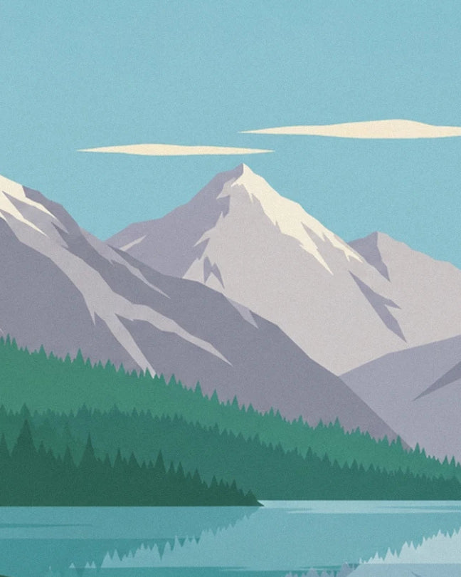 The snow-covered peaks above the conifer forests and turquoise lake