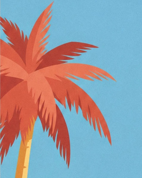 The red and orange fronds of a palm tree with a golden trunk against a blue sky
