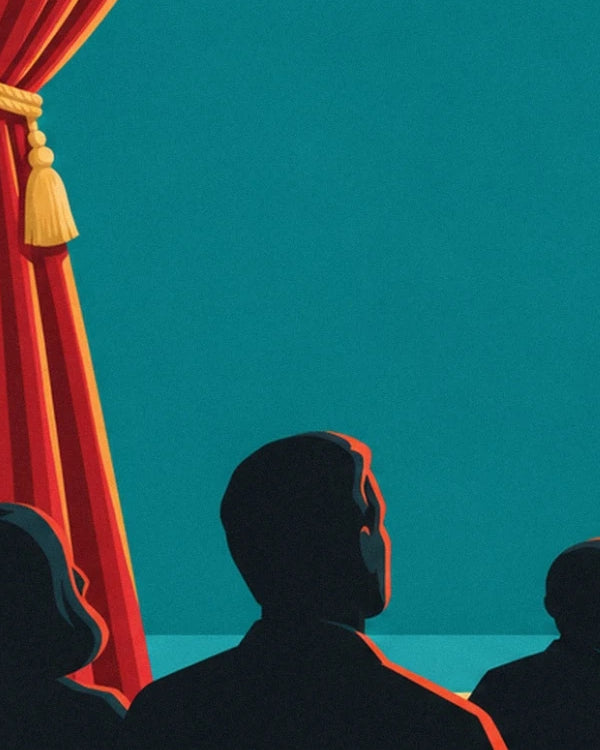 The dark silhouettes of the audience facing the stage, near the red curtain