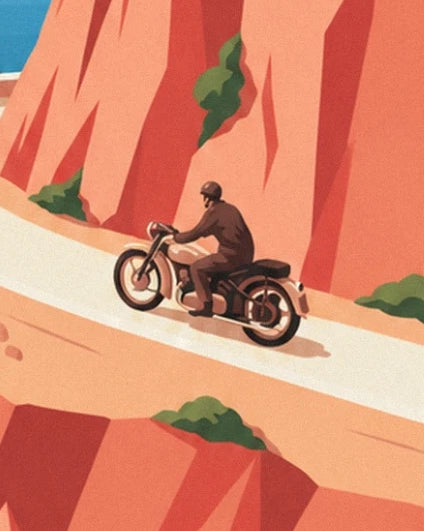 Le motard en tenue brune sur sa moto, entre les falaises orangées de l’Estérel