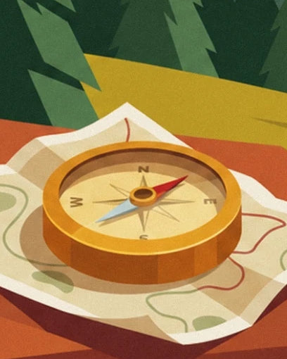 A golden compass with a red and blue needle on an unfolded walking map