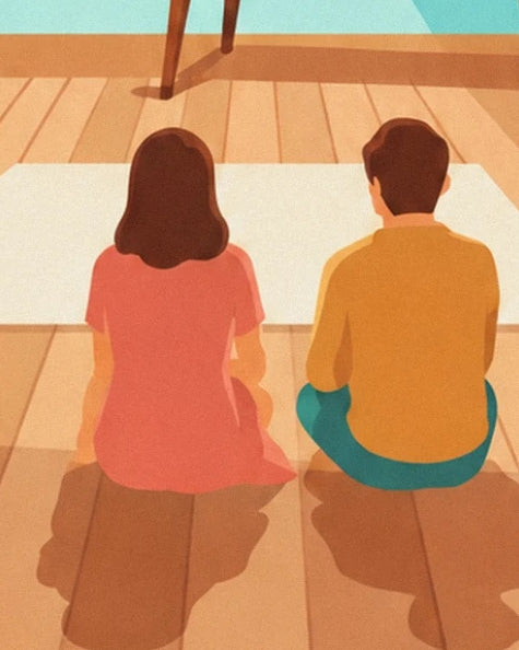The 2 viewers in pink and yellow seated on the wooden floor, seen from behind