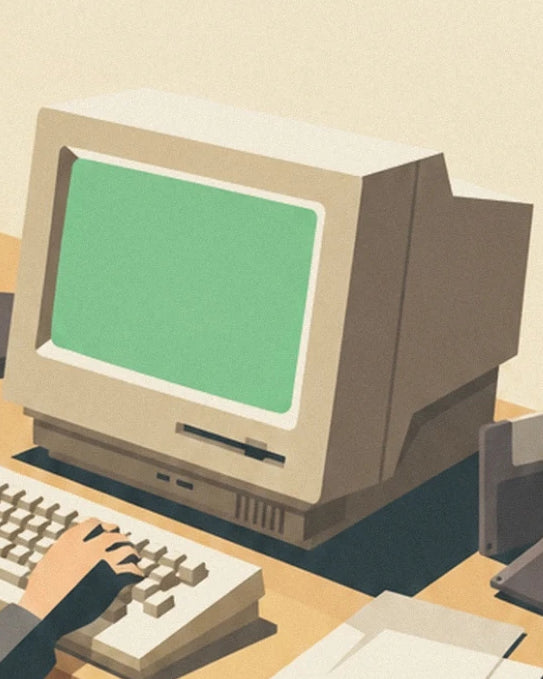The beige computer with its green screen and the keyboard beneath the user's hand