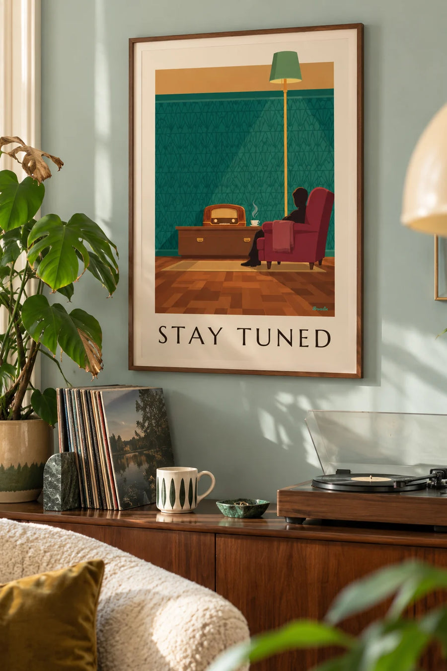 Poster of a wooden radio and a red armchair in a living room: framed on the wall