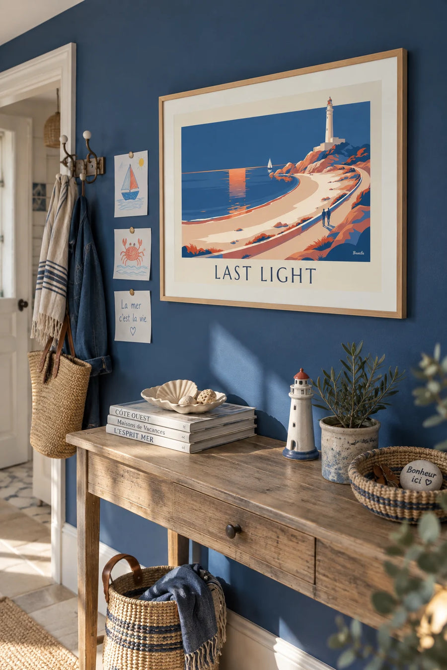 Poster of a sunset over a beach and its white lighthouse: framed on the wall