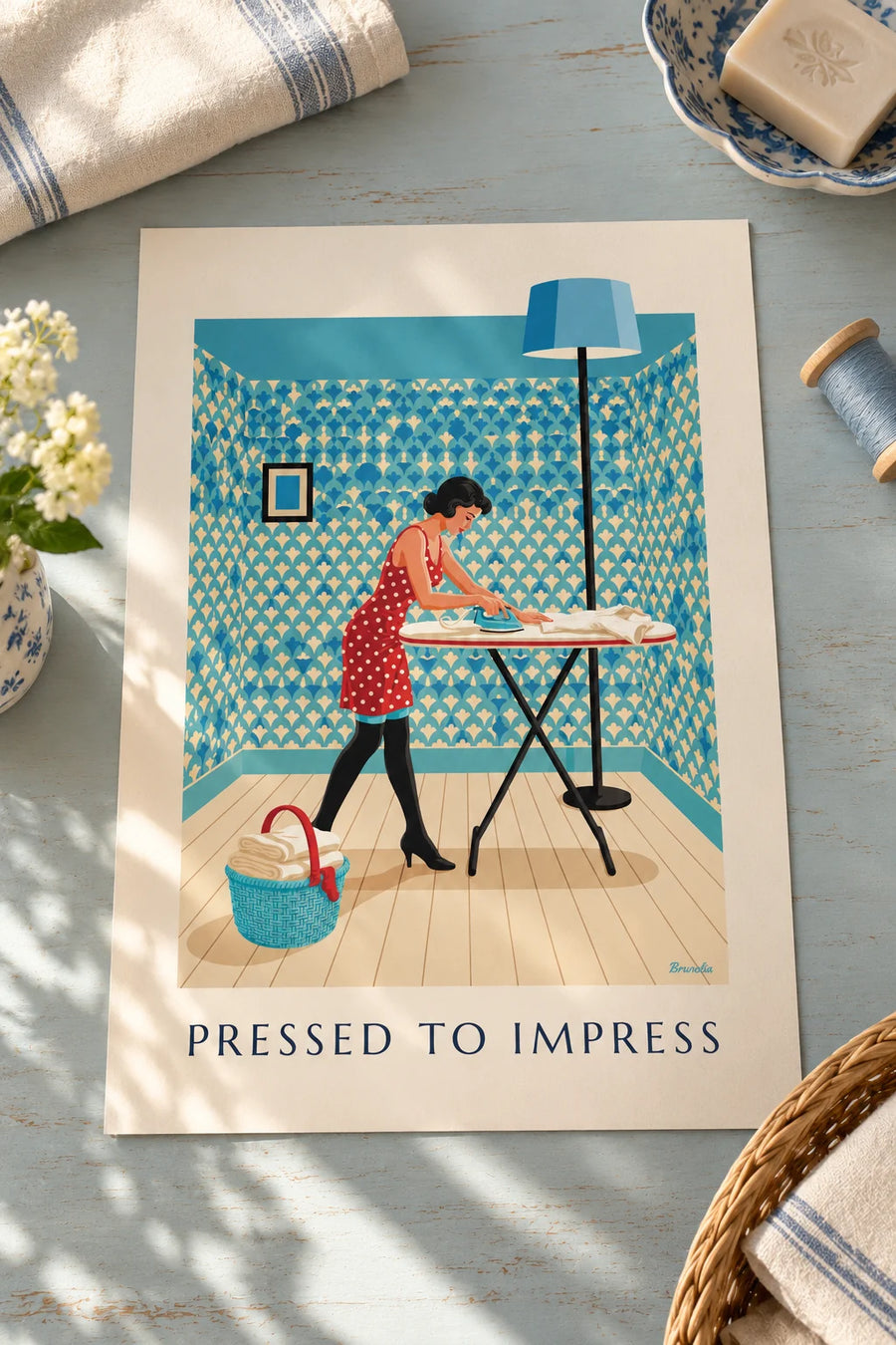 Affiche pin-up repassant une chemise sur sa planche à repasser : posée sur une table